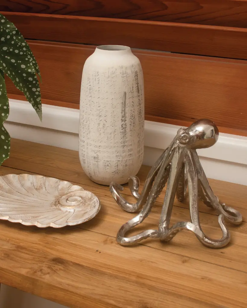 Decorative table with vase, octopus, and shell plate.